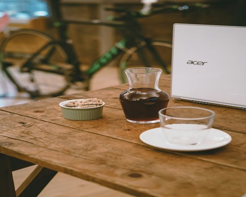 Glass of water on a wooden desk beside a laptop
